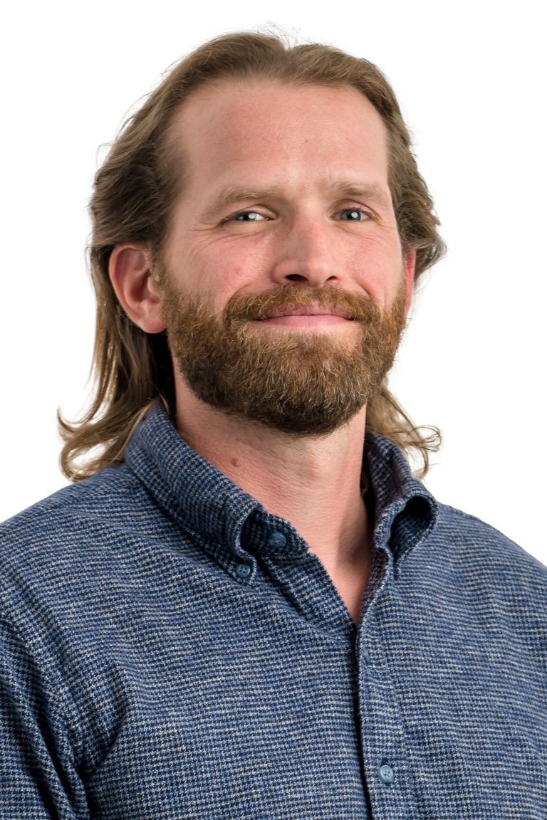 Photograph of Dr. Timothy Partridge from the chest up wearing a blue collared shirt